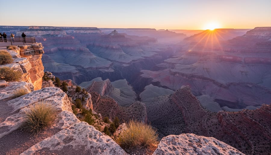 Hiker silhouetted at Grand Canyon South Rim sunrise overlooking layered red rock
